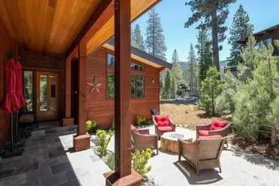 a porch of a cabin with chairs and a table at Palisades Tahoe Mountain Oasis in Olympic Valley