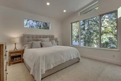 a bedroom with a large bed and two windows at Palisades Tahoe Mountain Oasis in Olympic Valley