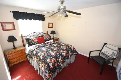 a bedroom with a bed and a fan and a chair at Forward-Lake Area in Bass Lake