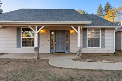 a white house with a gray door and a driveway at Lupine Landing in Mariposa