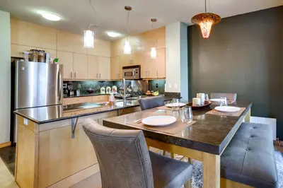 a kitchen with a table with chairs and a refrigerator at Mammoth Lakes Condo with Fireplace Near Skiing! in Mammoth Lakes