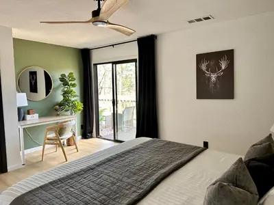 a bedroom with a bed and a desk and a ceiling fan at Prime location Yosemite Adventure by Casa Oso in Oakhurst