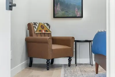 a brown chair sitting in a corner next to a table at The Charlotte Sequoia Motel R2 in Three Rivers
