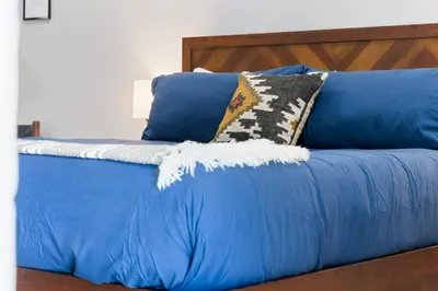 a blue bed with blue sheets and pillows at The Charlotte Sequoia Motel R2 in Three Rivers