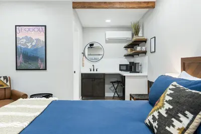 a bedroom with a blue bed and a sink at The Charlotte Sequoia Motel R2 in Three Rivers