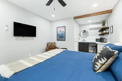 a bedroom with a blue bed and a flat screen tv at The Charlotte Sequoia Motel R2 in Three Rivers