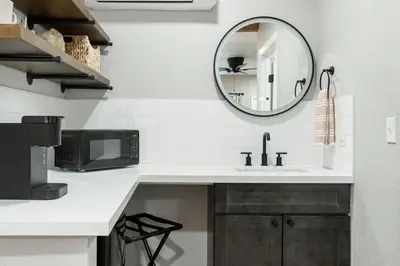 a white kitchen with a sink and a mirror at The Moro | Sequoia Motel RM3 in Three Rivers