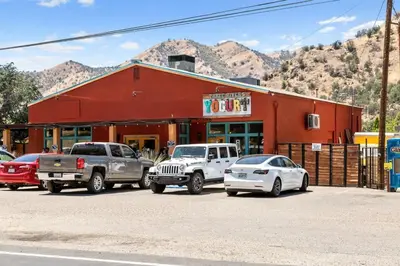 a group of cars parked in front of a red building at The Belle Sequoia Motel RM9 in Three Rivers