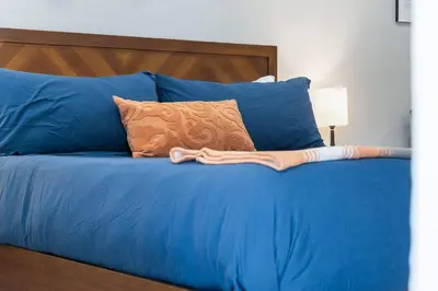 a blue bed with blue pillows and a blanket on it at The Tokopah Sequoia Motel RM 1 in Three Rivers