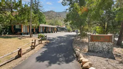 a road next to a building with a sign on it at The Tokopah Sequoia Motel RM 1 in Three Rivers