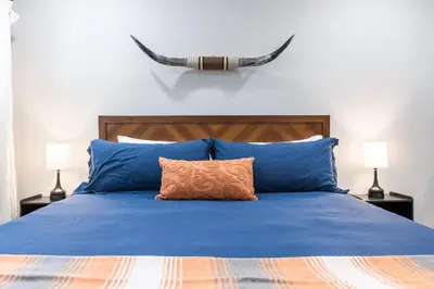 a bed with blue pillows and antlers on the wall at The Tokopah Sequoia Motel RM 1 in Three Rivers