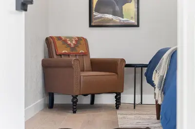 a brown chair sitting in a corner of a room at The Congress Sequoia Motel RM6 in Three Rivers