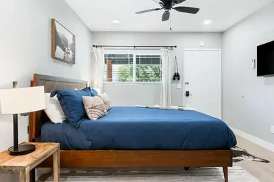 a bedroom with a bed with blue sheets and a ceiling fan at The Congress Sequoia Motel RM6 in Three Rivers