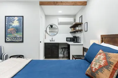 a bedroom with a blue bed and a sink at The Heather Sequoia Motel RM 4 in Three Rivers