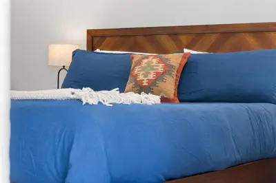 a blue bed with blue sheets and pillows at The Heather Sequoia Motel RM 4 in Three Rivers