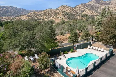an overhead view of a swimming pool with mountains in the background at The Heather Sequoia Motel RM 4 in Three Rivers