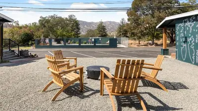 two wooden chairs sitting next to a tennis court at The Heather Sequoia Motel RM 4 in Three Rivers