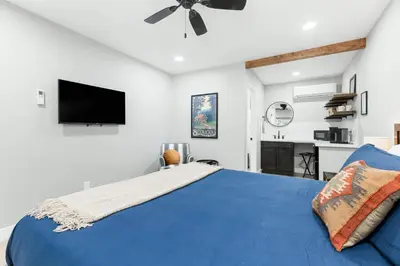 a bedroom with a blue bed and a flat screen tv at The Heather Sequoia Motel RM 4 in Three Rivers