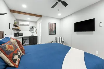 a bedroom with a blue bed and a flat screen tv at The Rae | Sequoia Motel RM 5 in Three Rivers