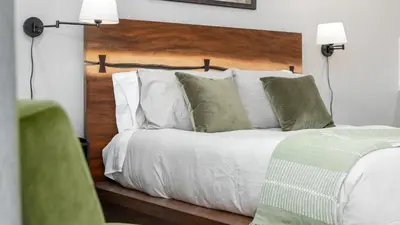 a bedroom with a bed with white sheets and pillows at The Whitney- Sequoia Motel RM7 in Three Rivers