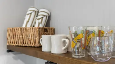 a row of glasses sitting on a wooden shelf at The Whitney- Sequoia Motel RM7 in Three Rivers
