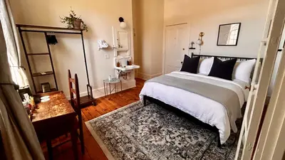 a bedroom with a bed and a table with a rug at Imperial Hotel + Restaurant in Amador City
