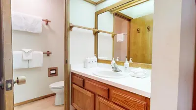 a bathroom with a sink and a toilet and a mirror at Snowcreek I #52 condo in Mammoth Lakes