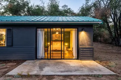 a small house with a blue roof and a glass door at Manzanita Rest in Mariposa