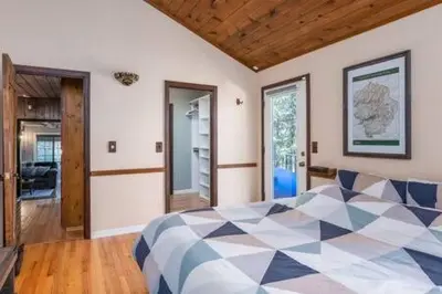 a bedroom with a bed with a checkered blanket at Cedar Ridge Hot Tub BBQ Sleeps 8 in Oakhurst