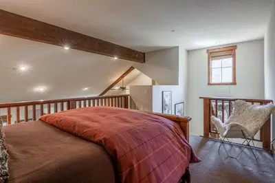 a bedroom with a bed and a chair at Lodges 1112 - 3 Bed townhome with Loft in Mammoth Lakes