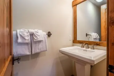 a bathroom with a sink and a mirror and towels at Lodges 1112 - 3 Bed townhome with Loft in Mammoth Lakes