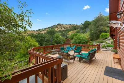 a wooden deck with chairs and a table on it at SEQUOIA LOOKOUT LODGE in Three Rivers