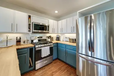 a kitchen with blue cabinets and a stainless steel refrigerator at Steps to Beach Family Home with Views in Tahoe City in Tahoe City