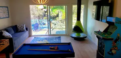 a living room with a pool table on the floor at Retro House on the River ! in Three Rivers