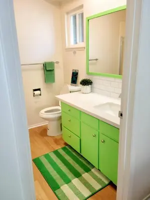 a green bathroom with a sink and a toilet at Retro House on the River ! in Three Rivers