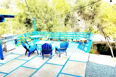 a patio with a table and chairs and a grill at Retro House on the River ! in Three Rivers
