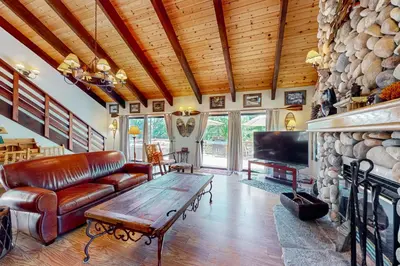 a living room with a couch and a fireplace at Wishing Well Cabin in Bass Lake