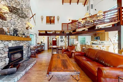 a living room with a couch and a fireplace at Wishing Well Cabin in Bass Lake