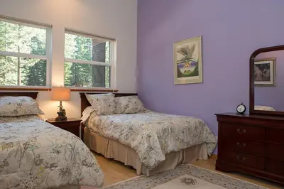 a bedroom with two beds and a dresser and two windows at Big Luxury South Lake Tahoe Home in South Lake Tahoe