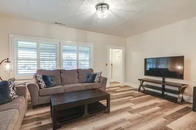 a living room with a couch and a flat screen tv at Sunny Turlock Cottage Walk to Downtown! in Turlock