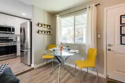 a kitchen and dining room with a table and yellow chairs at Waterfront Mariposa Hideaway Hot Tub and Mtn Views! in Mariposa