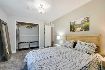 a bedroom with a large bed with a white comforter at Waterfront Mariposa Hideaway Hot Tub and Mtn Views! in Mariposa