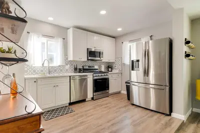a kitchen with stainless steel appliances and white cabinets at Waterfront Mariposa Hideaway Hot Tub and Mtn Views! in Mariposa