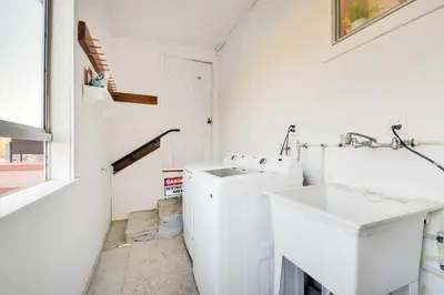 a white laundry room with a sink and a washing machine at Waterfront Mariposa Vacation Rental with Hot Tub in Mariposa