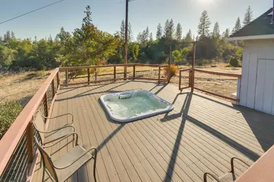 a hot tub on a deck with two chairs at Waterfront Mariposa Vacation Rental with Hot Tub in Mariposa