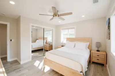 a white bedroom with a bed and a mirror at Dennison House in Three Rivers
