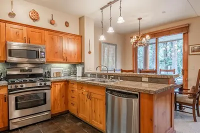 a kitchen with wooden cabinets and stainless steel appliances at Cabins 1 in Mammoth Lakes