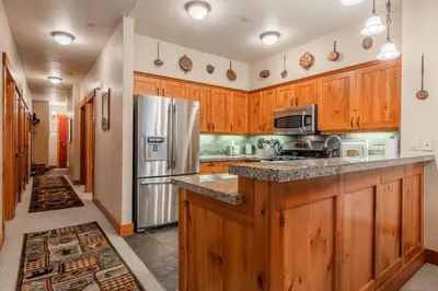 a kitchen with wooden cabinets and a stainless steel refrigerator at Cabins 1 in Mammoth Lakes