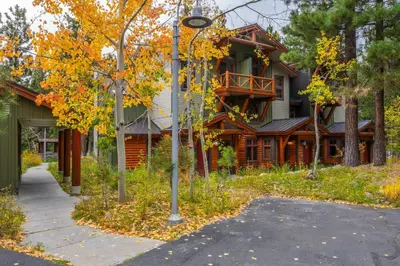 a house on a street with trees and a sidewalk at Cabins 1 in Mammoth Lakes