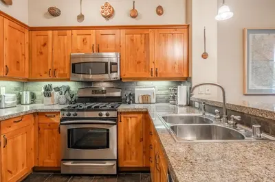 a kitchen with wooden cabinets and a stove and a sink at Cabins 1 in Mammoth Lakes